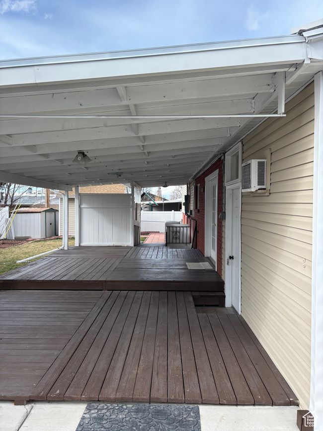 Wooden deck featuring an outbuilding, a wall mounted AC, and a storage shed | Image 17