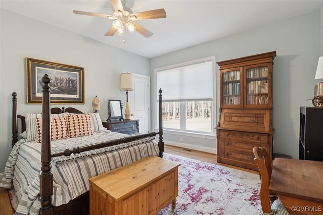 Bedroom with light wood-type flooring, baseboards, and a ceiling fan | Image 26