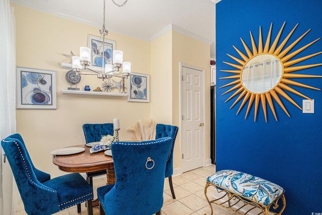 Dining space featuring a chandelier, crown molding, and tile patterned floors | Image 6