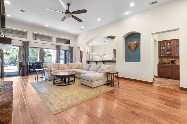 Living room with a ceiling fan, wood finished floors, recessed lighting, and arched walkways | Image 12
