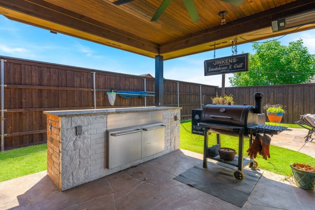 Fenced backyard with a ceiling fan and a patio | Image 33