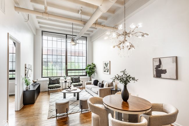 dining room with beam ceiling, a towering ceiling, hardwood / wood-style floors, a chandelier, and coffered ceiling | Image 11