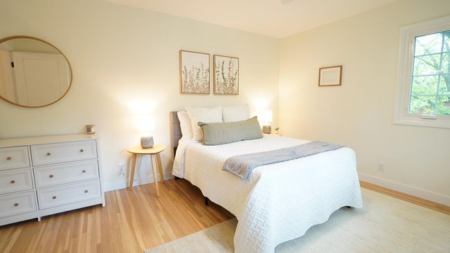 The large second bedroom is located on the upper level and is conveniently located next to the hall bath. It brings in a ton of natural light, and also features newly refinished white oak floors and a neutral color palette. | Image 25
