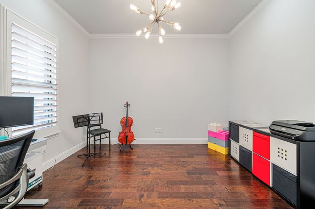 Office featuring crown molding, baseboards, wood finished floors, and an inviting chandelier | Image 9