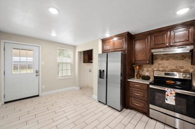 Kitchen has the wow factor with new cabinets, backspash, and stainless stove. | Image 3