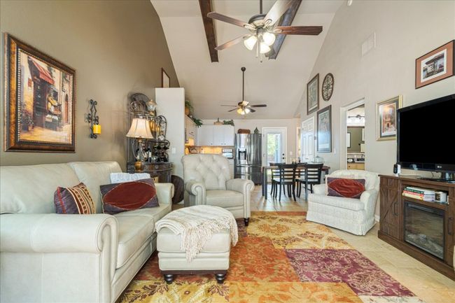 Living area featuring high vaulted ceiling, ceiling fan, and visible vents | Image 7