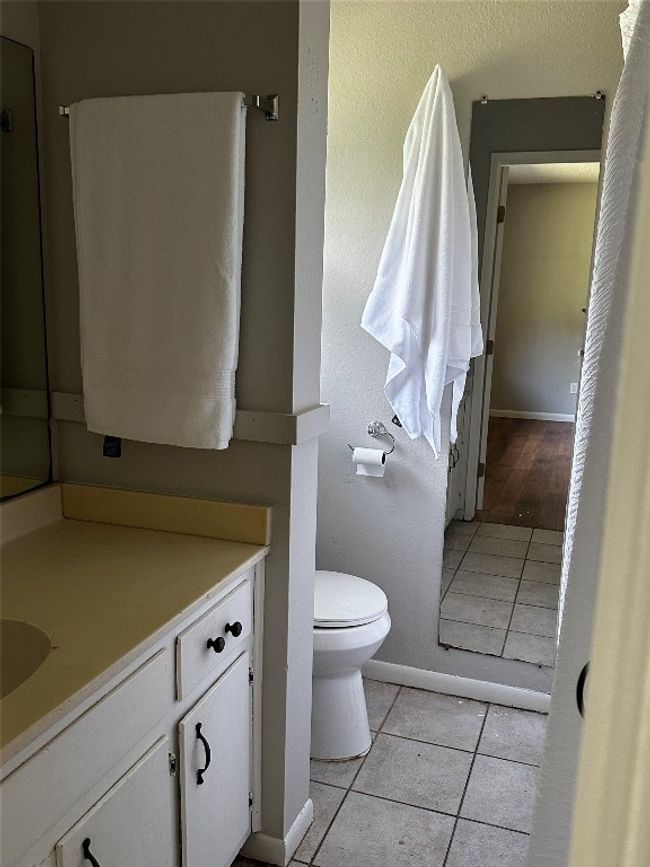 Bathroom with tile patterned floors, a textured wall, and vanity | Image 16