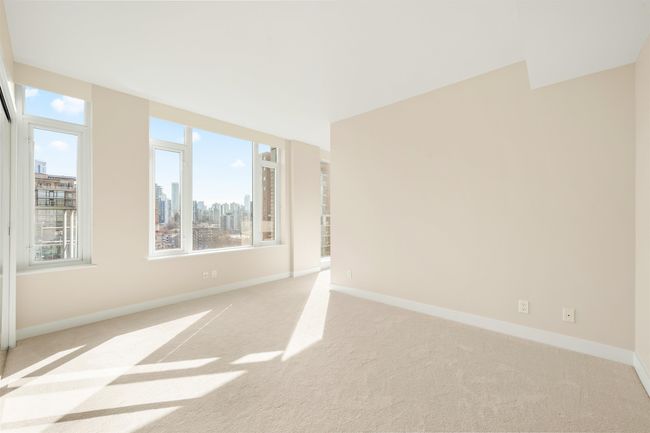 Unfurnished room featuring baseboards, light carpet, and a city view | Image 6