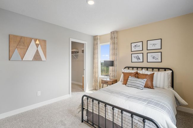 Each of the spacious secondary bedrooms feature well thought out window locations and a walk-in closet. Model photo. Options and colors will vary. | Image 22
