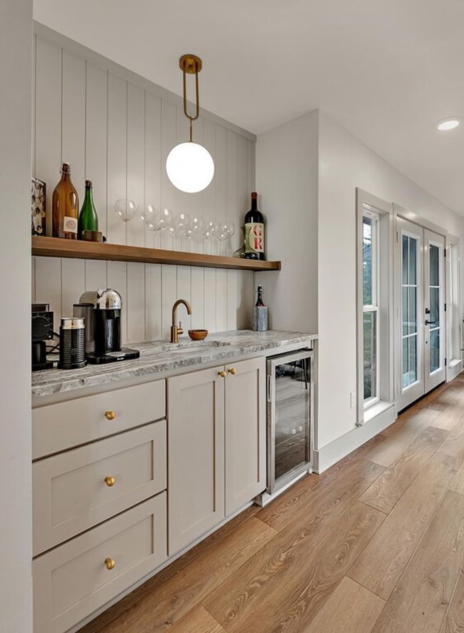 Indoor bar with beverage cooler, light wood-style flooring, french doors, hanging light fixtures, and recessed lighting | Image 17