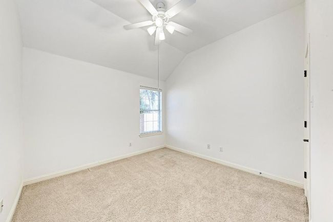 Carpeted empty room with ceiling fan, baseboards, and lofted ceiling | Image 29