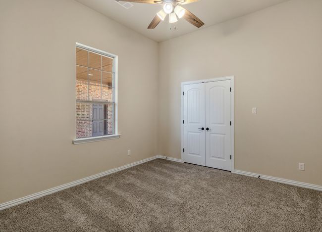 Unfurnished bedroom with carpet, baseboards, a closet, and ceiling fan | Image 23