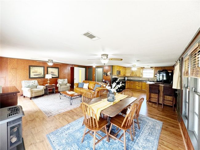 Dining room featuring light wood-style flooring, a ceiling fan, and visible vents | Image 8