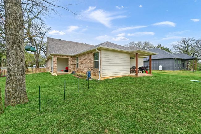 Rear view of house with fence, a yard, and a patio | Image 27