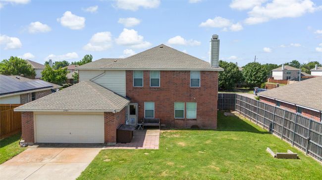 Rear view of house with brick siding, driveway, a fenced backyard, a chimney, and a garage | Image 29