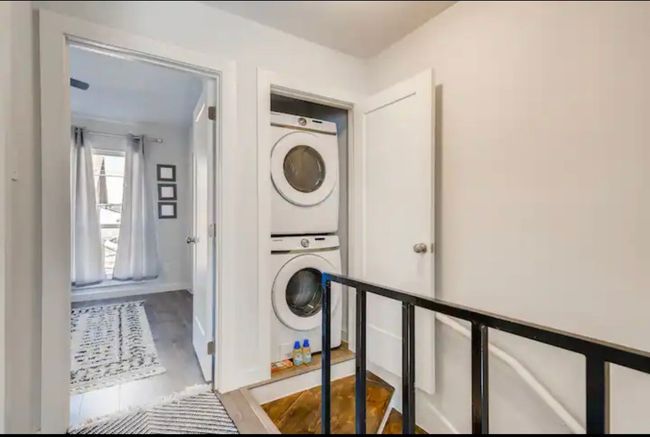 Laundry room with stacked washer / dryer, baseboards, and wood finished floors | Image 13