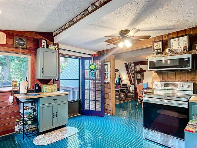 Kitchen view of the doorway leading to the side deck. Also note in the background the paddle steps to the loft area, which are much easier to climb than the traditional ladder! | Image 17