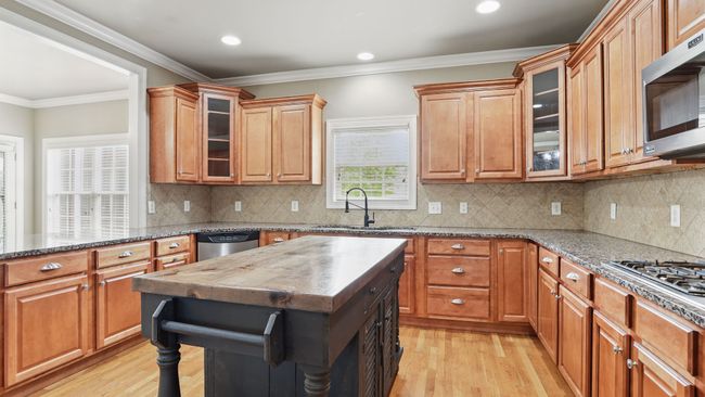 Cook up fabulous meals with the gas stove, granite countertops, and lots of cherry wood cabinet space. | Image 8