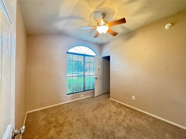 Carpeted spare room featuring ceiling fan, lofted ceiling, and a smoke detector | Image 23