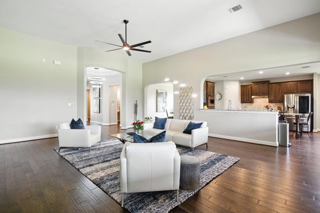 Living room featuring arched walkways, ceiling fan, and dark wood finished floors | Image 5