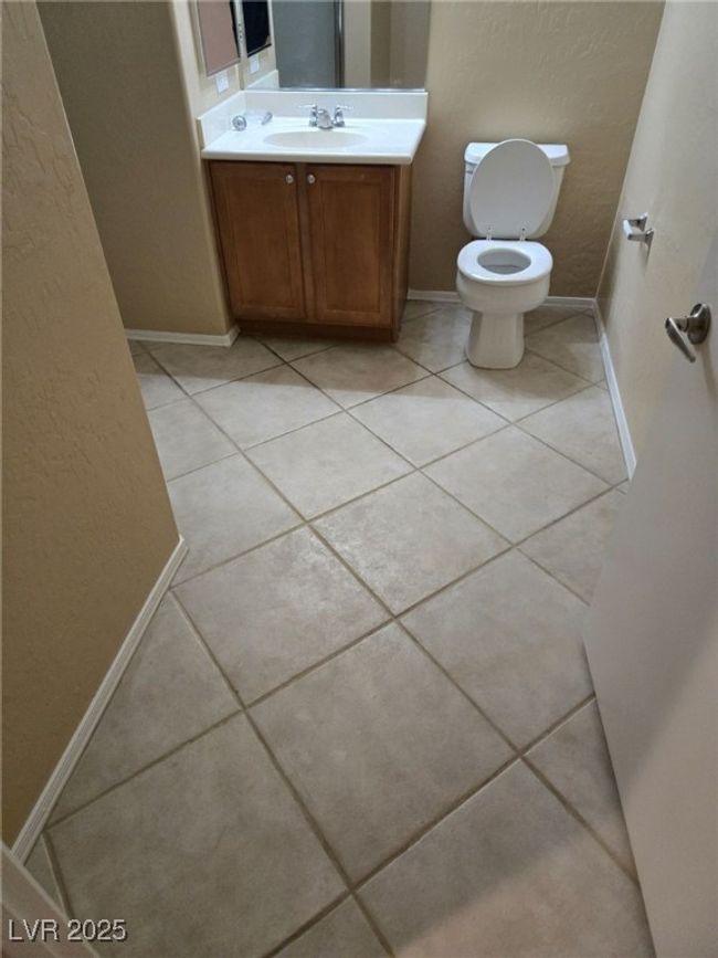Half bath with toilet, tile patterned flooring, vanity, and baseboards | Image 20