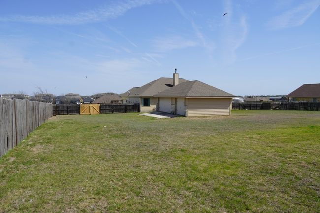 View of yard featuring a fenced backyard and a patio area | Image 23