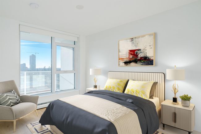 Bedroom with light wood-style floors, a baseboard heating unit, and a view of city | Image 19
