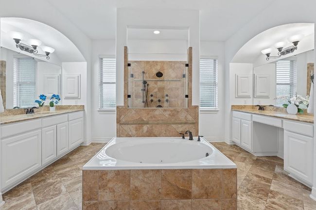 Bathroom featuring a whirlpool tub, two vanities, a walk in shower, and baseboards | Image 15