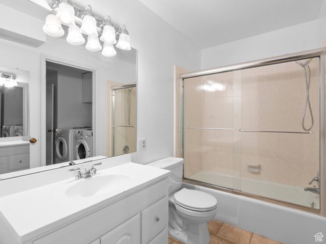Full bath with separate washer and dryer, vanity, and enclosed tub / shower combo | Image 9