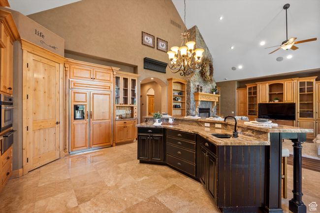 Kitchen with a sink, high vaulted ceiling, arched walkways, open shelves, and ceiling fan | Image 30