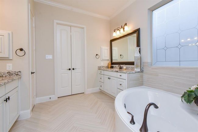 Primary bath features two vanities, large tub, and walk-in shower | Image 14