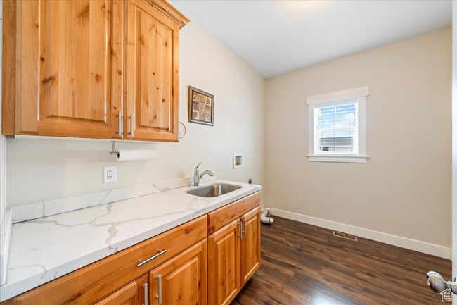 Clothes washing area featuring dark wood-style floors, a sink, baseboards, visible vents, and washer hookup | Image 35