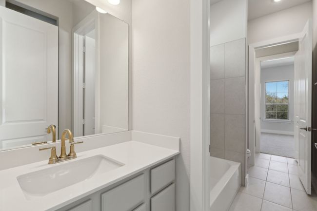 Full bathroom with vanity, tile patterned flooring, and washtub / shower combination | Image 26
