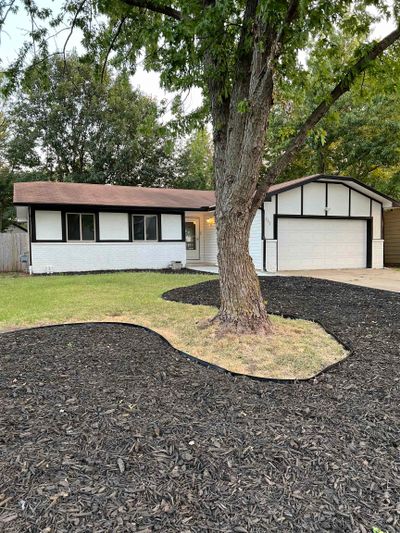 Ranch-style house featuring a garage and a front lawn | Image 1