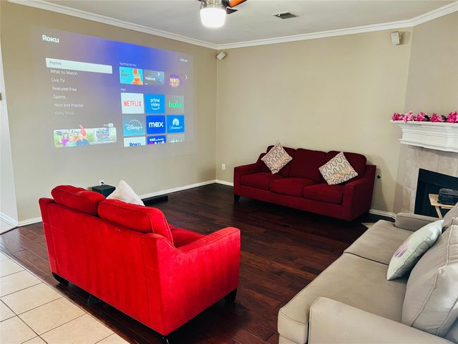 Living room featuring hardwood floors, crown molding, a tile fireplace, and ceiling fan | Image 8