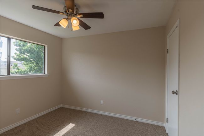 Carpeted empty room with a ceiling fan and baseboards | Image 26