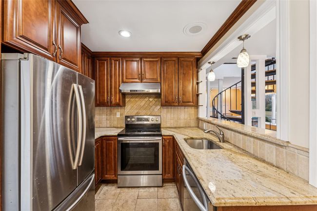 Kitchen featuring a sink, stainless steel appliances, tasteful backsplash, and exhaust hood | Image 5
