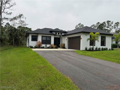 Prairie-style house with a garage and a front lawn | Image 1