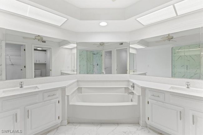 Bathroom featuring vanity, ceiling fan, a bath, and tile patterned flooring | Image 12