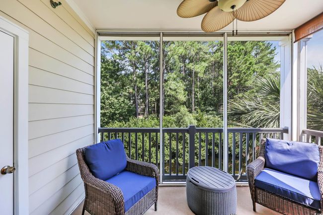 Sunroom / solarium featuring ceiling fan and view of scattered trees | Image 22