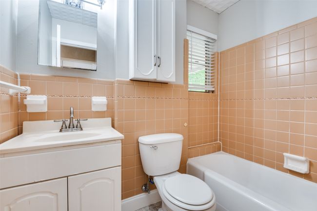 Full bathroom featuring toilet, tile walls, and vanity | Image 17
