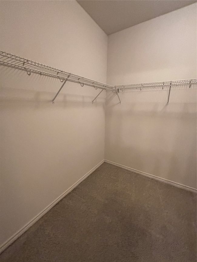 Spacious closet featuring dark colored carpet | Image 18