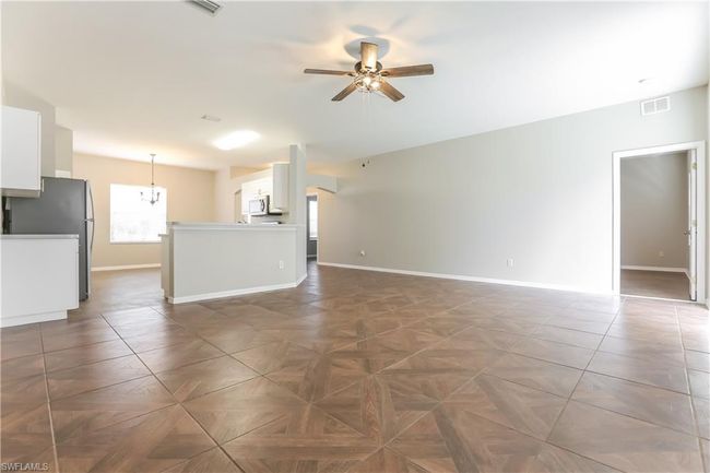 Unfurnished living room with ceiling fan and baseboards | Image 4