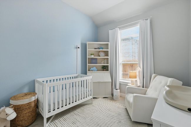 Bedroom featuring lofted ceiling and a crib | Image 18