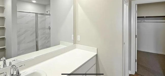 Bathroom with a walk in closet, a stall shower, and vanity | Image 13