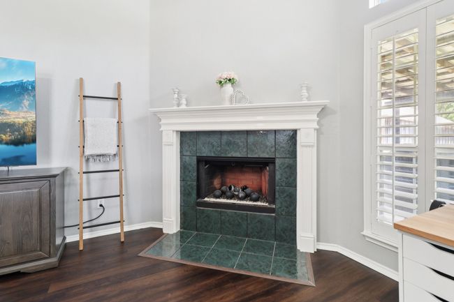 Detailed view of wood finished floors, a fireplace, and baseboards | Image 8