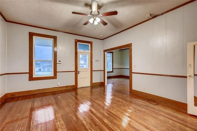 Unfurnished room with wood-type flooring, ceiling fan, crown molding, and baseboards | Image 20