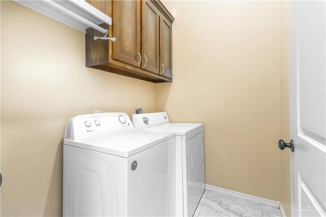 Laundry room with cabinets and washing machine and clothes dryer | Image 6
