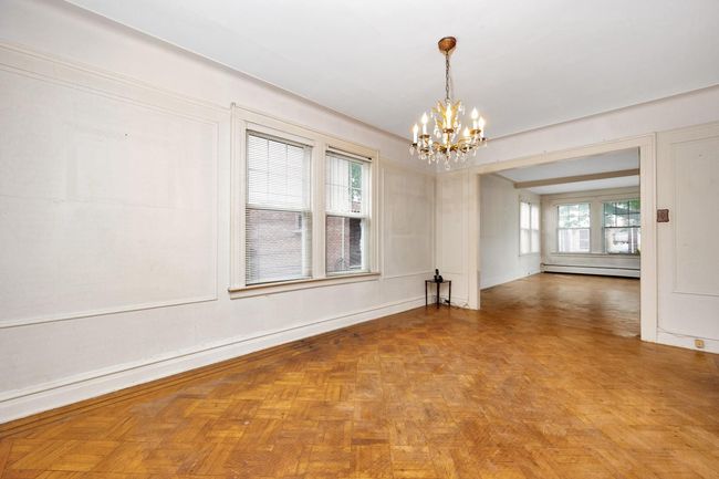 Empty room featuring a chandelier and baseboard heating | Image 10