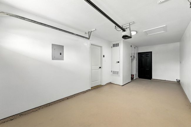 Garage featuring electric panel and a garage door opener | Image 23